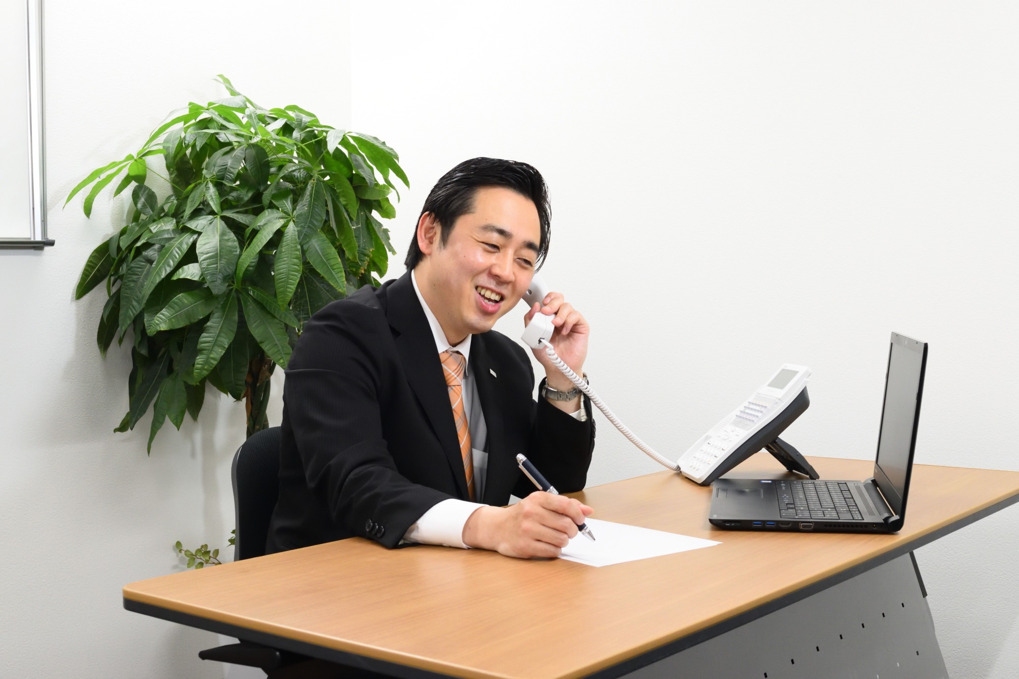 写真：電話応対中の男性